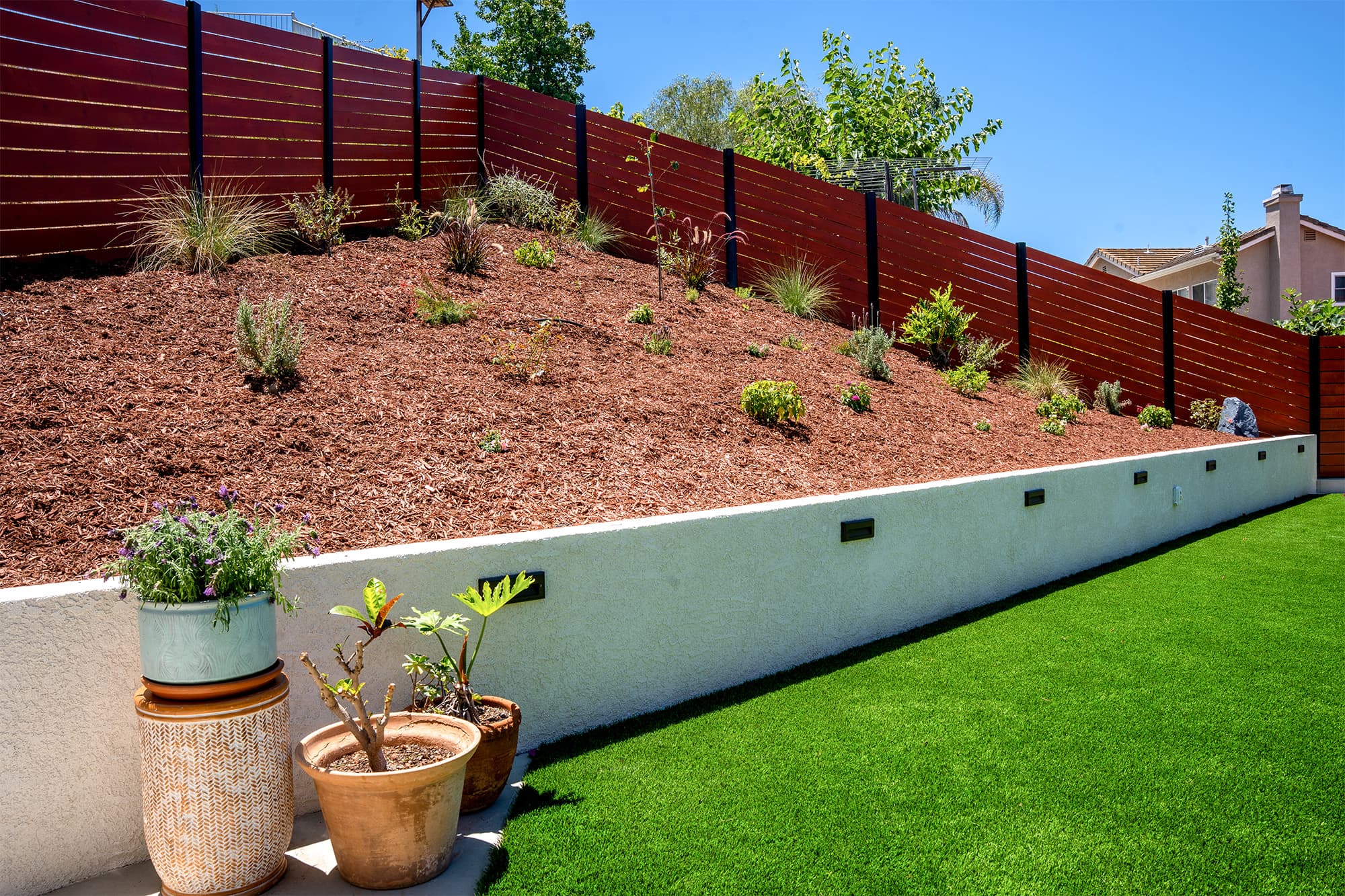 Backyard remodel with artificial turf, retaining wall and landscaping