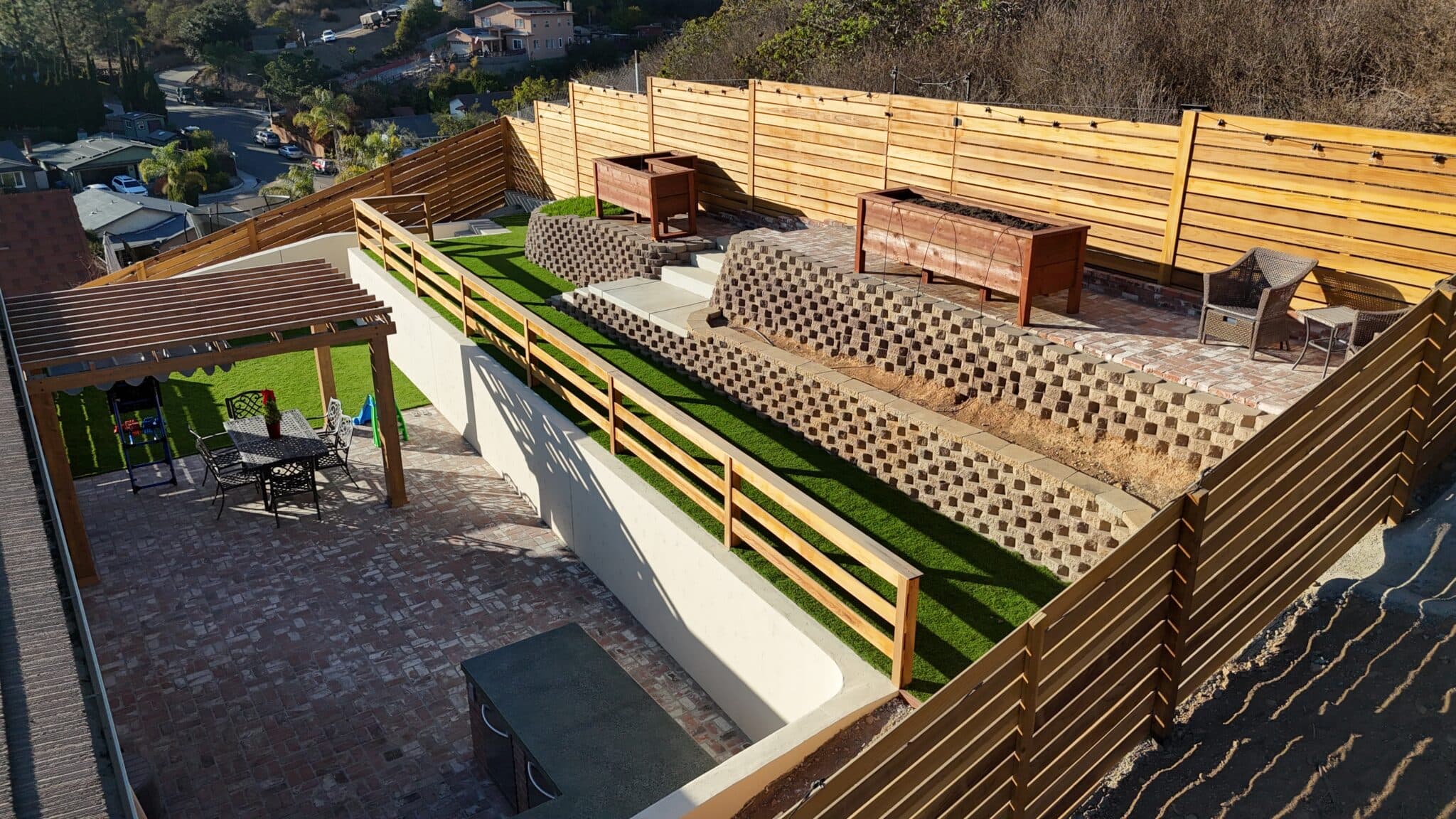 Outdoor seating area with privacy fencing and lush greenery