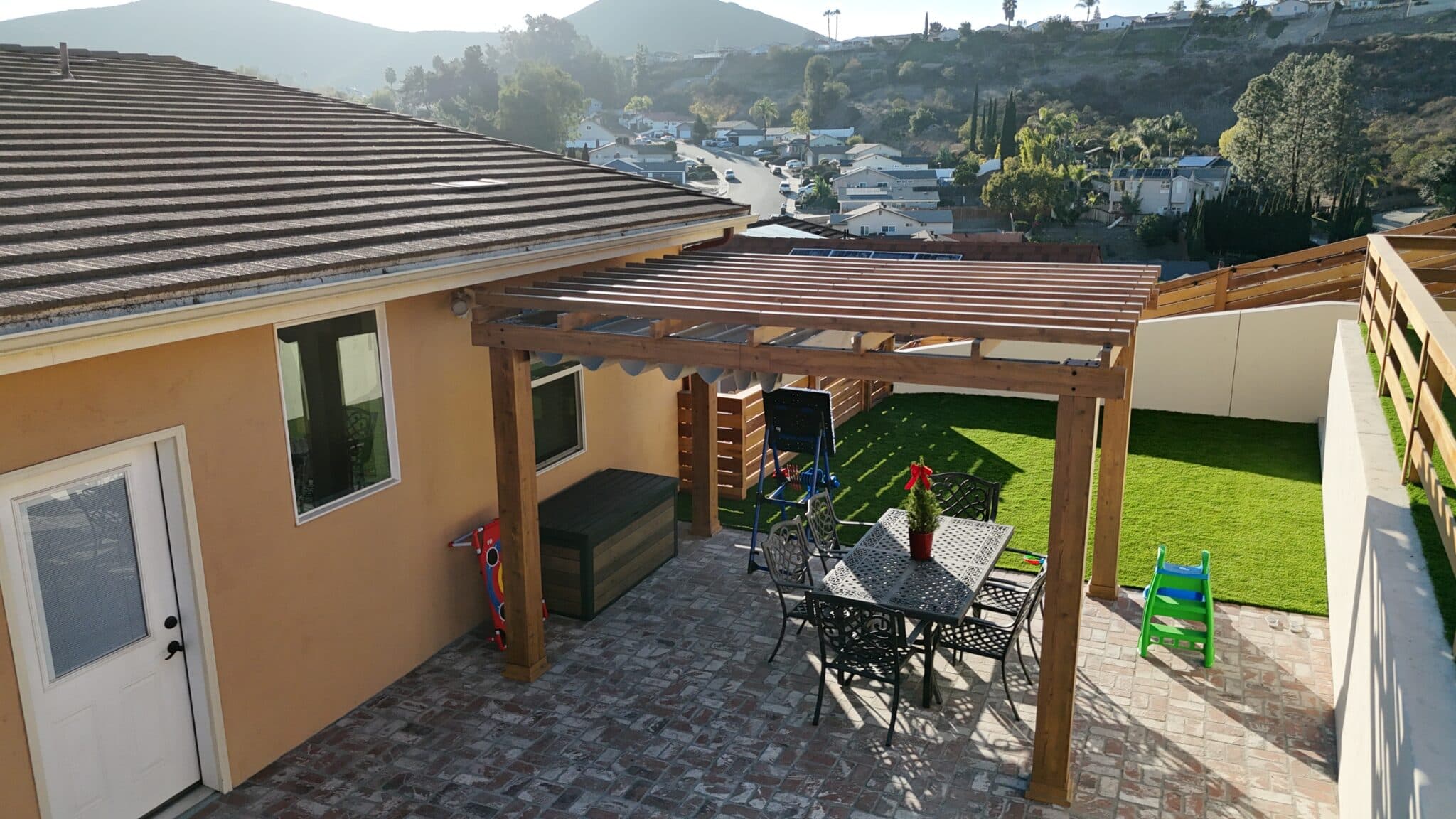 Spacious outdoor lounge area with privacy fence, concrete patio, and modern seating.