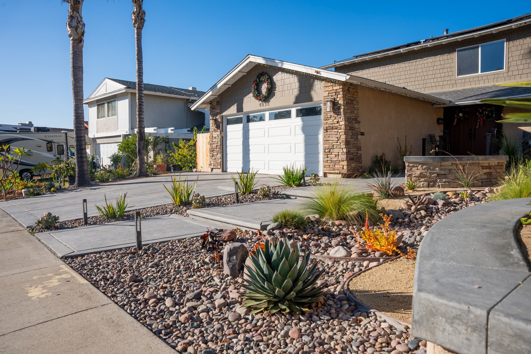 Custom concrete paths surrounded by desert plants and stone accent