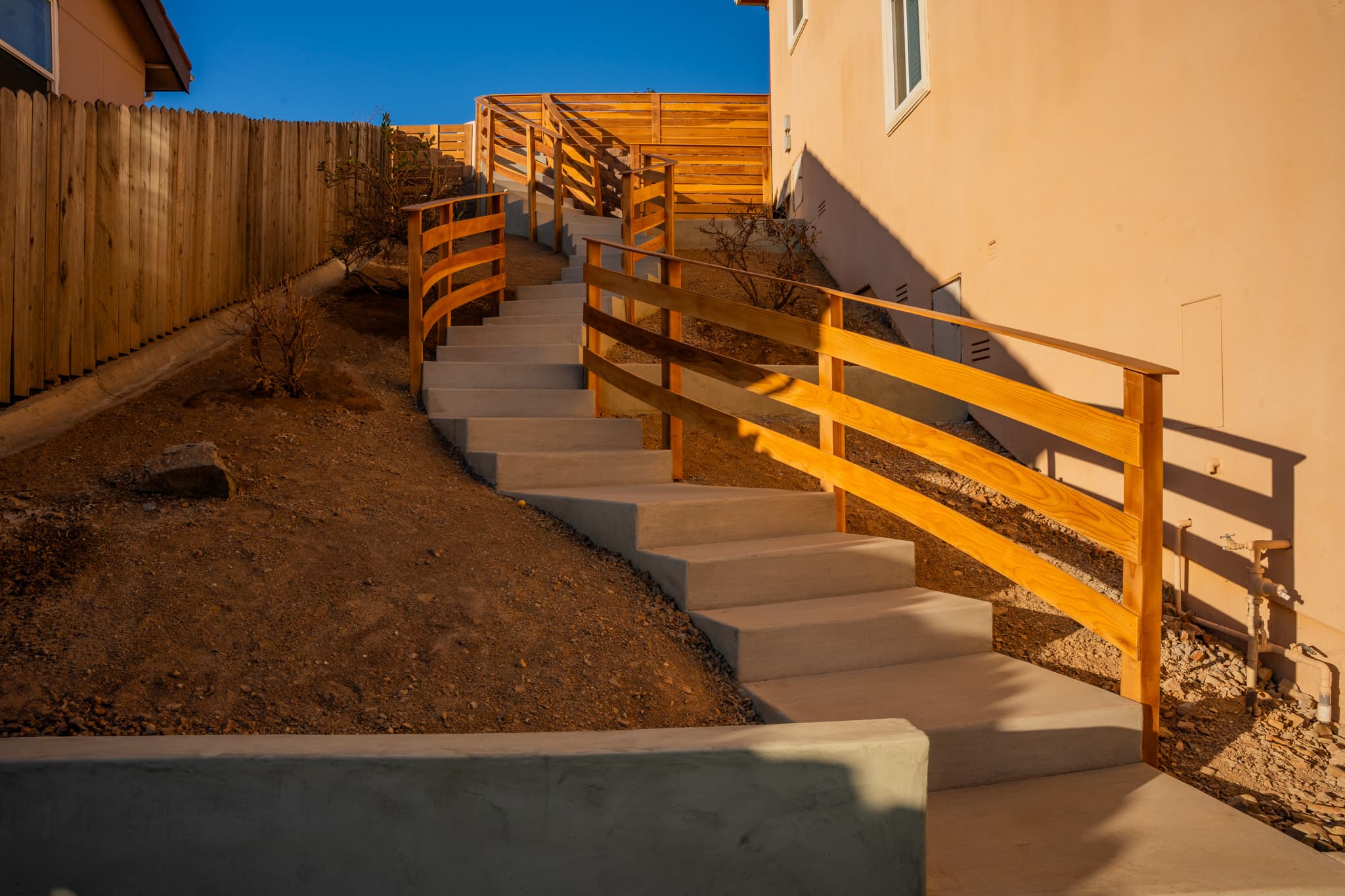 Modern patio with fire pit, lounge chairs, and horizontal slat privacy fence