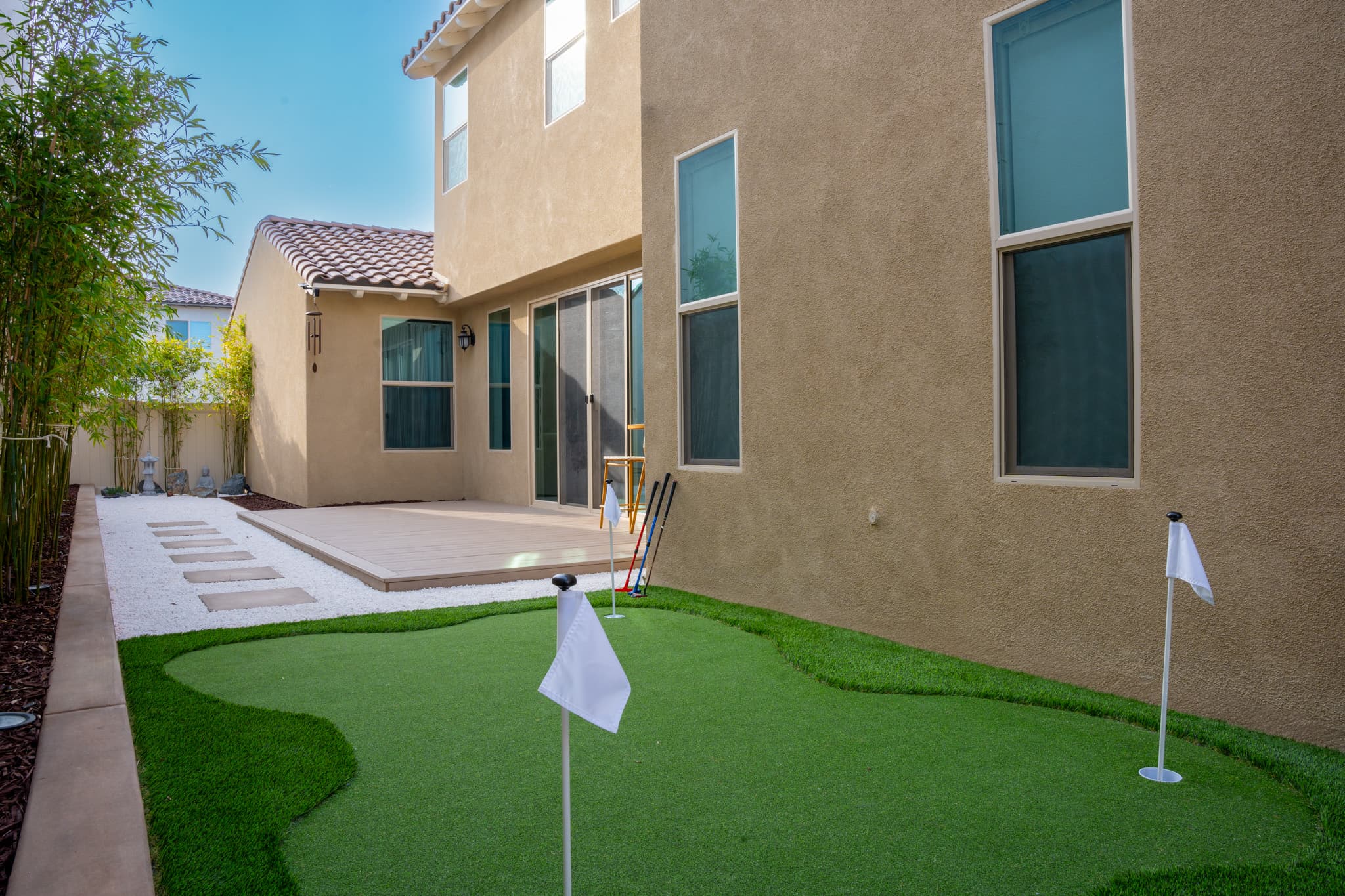 Backyard transformation with a custom putting green and artificial grass.