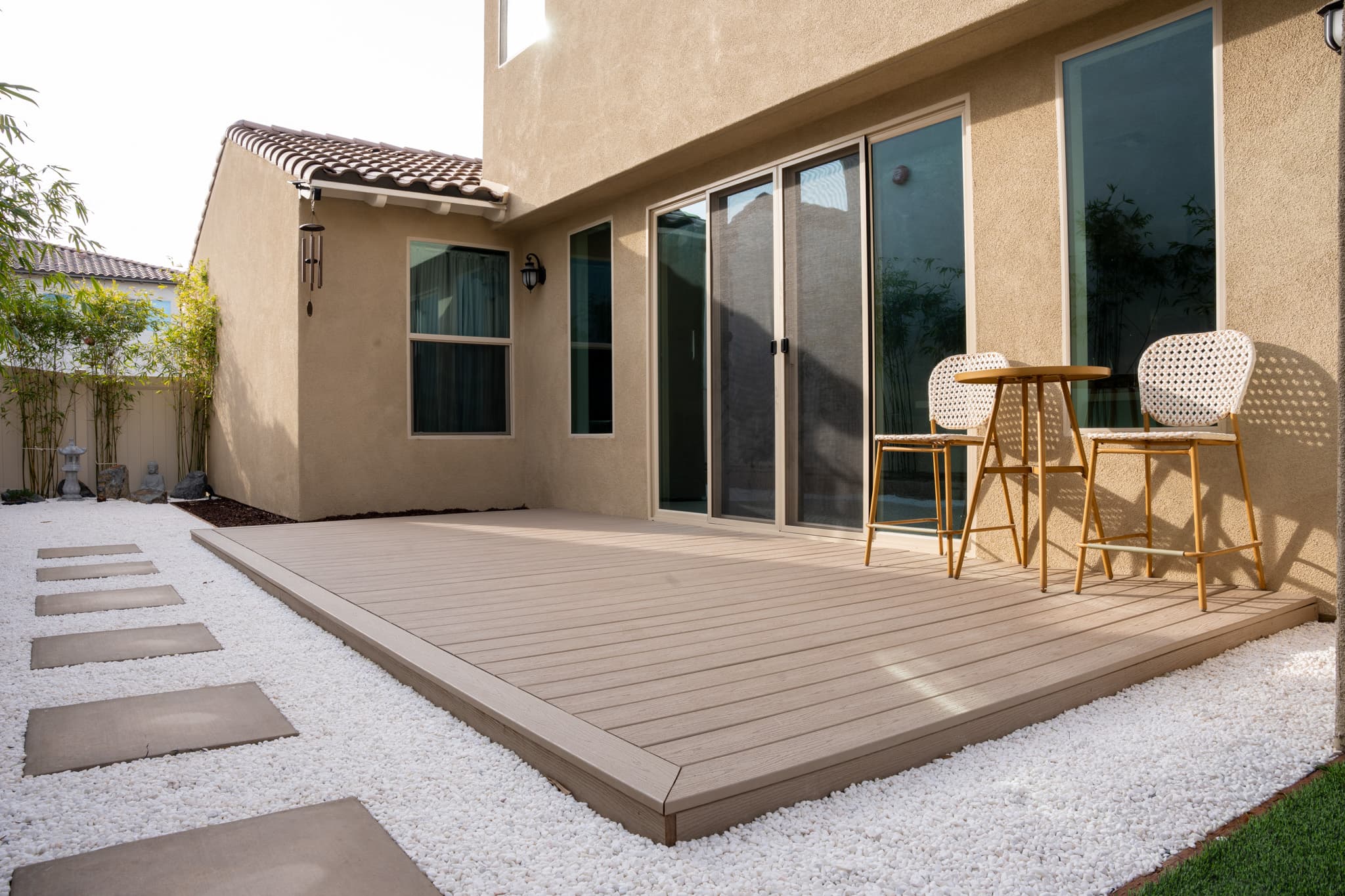 Modern backyard featuring a stylish deck, stepping stone walkway, and low-maintenance landscape.